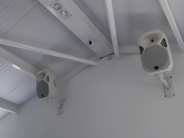 White speakers installed on a wallbracket for fitness gym leisure centre