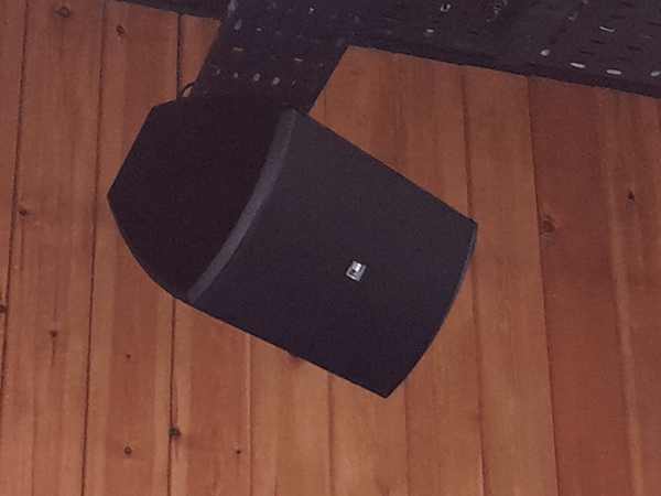 Black PA loudspeaker wall mounted to a bar for a sound system av installation