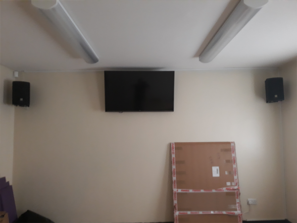 in the process of installing a TV and PA loudspeakers for better sound during the church ceremony